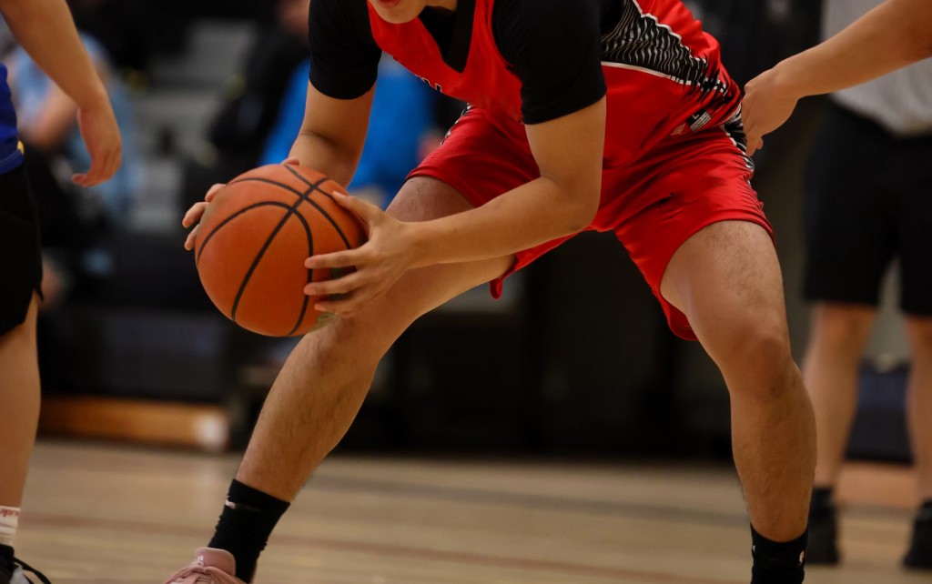 Basketball player in a ready stance holding the ball
